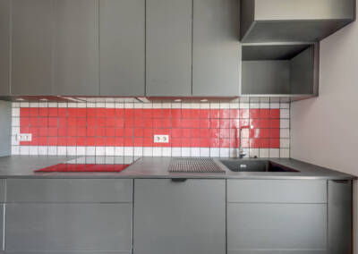 Détails de la crédence rouge et blanche avec des éléments gris clairs, par Béatrice Elisabeth, Architecte d'intérieur UFDI à Neuilly et Paris