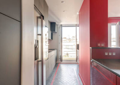 Effet de couloir avec un carrelage hexagonal gris foncé et liseré rouge, par Béatrice Elisabeth, Architecte d'intérieur UFDI à Neuilly et Paris